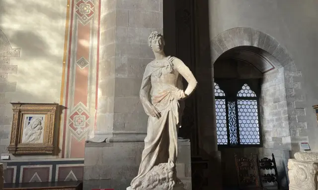 Statue de David par David Verrocchio, debout sur la tête de Goliath, dans un musée.