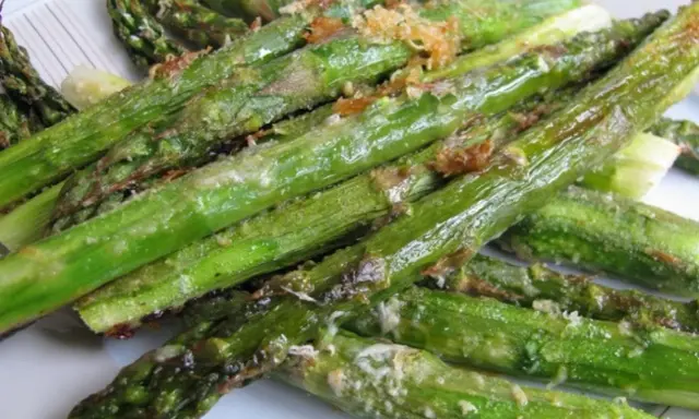 Pieczone szparagi z parmezanem na talerzu.