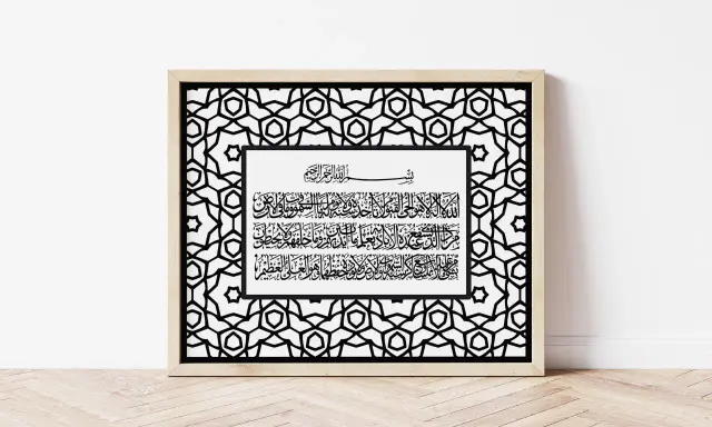 Gerahmte Kalligrafie mit arabischer Schrift auf weißem Hintergrund, umgeben von einem geometrischen Muster. Ein Vers erinnert daran, dass "und wir haben euch in paaren erschaffen".