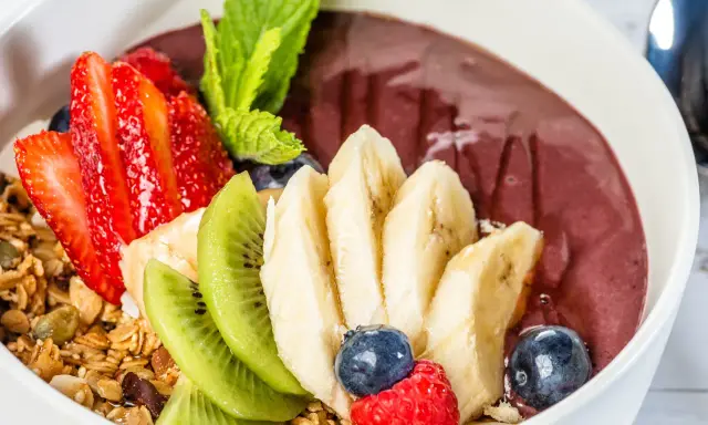 Acai-Bowl mit Erdbeeren, Bananen, Kiwi, Blaubeeren, Himbeeren und Granola. Was ist Acai? Eine gesunde Beere für dein Frühstück!