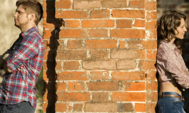 Un homme et une femme se tiennent de part et d'autre d'un mur de briques. Peut-on fixer quelque chose sur un mur mitoyen ?