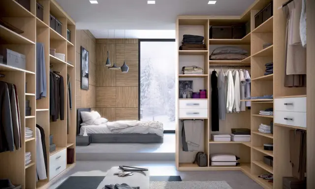 Une idée dressing chambre : un espace organisé avec des étagères en bois clair, des vêtements suspendus et pliés, et une vue sur un paysage enneigé.
