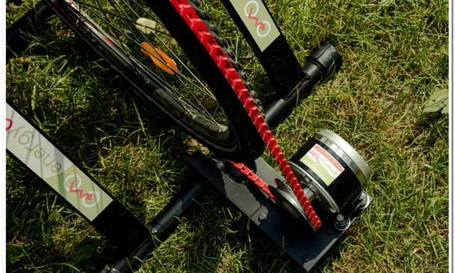 Rower produkujący prąd na trawie. Urządzenie z rolką i silnikiem, gotowe do generowania energii.