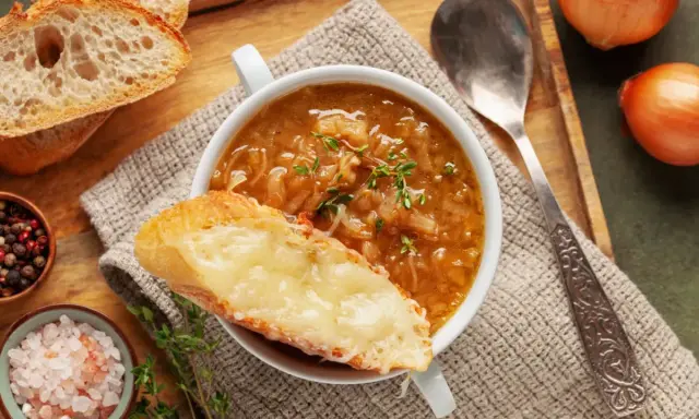 Une délicieuse recette de soupe à l'oignon, gratinée avec du fromage fondant sur une tranche de pain croustillant.