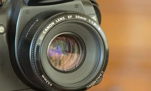 La fotocamera sfocata dopo caduta mostra un obiettivo Canon EF 50mm 1:1.8.