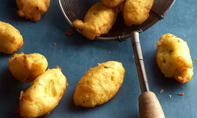 Goldbraune Dauphine Kartoffeln, frisch frittiert und auf einem Abtropfsieb. Ein Genuss für jeden Kartoffelliebhaber.
