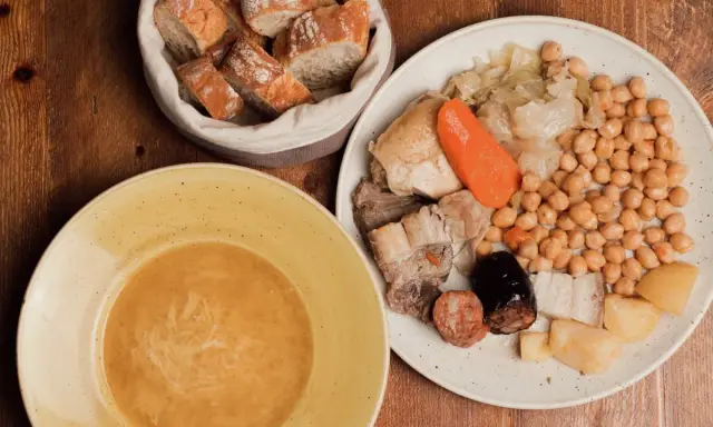 Un plato de comida típica de Madrid: cocido con garbanzos, carnes, verduras y pan.