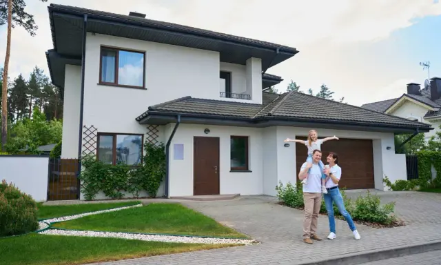 Rodzina przed nowoczesnym domem. Zastanawiasz się, ile trwa budowa domu 100m2?