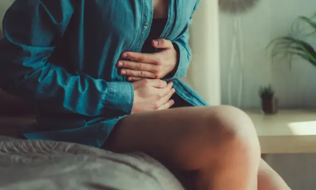 Osoba z bólem brzucha, objawem infekcji Clostridium difficile, która może prowadzić do śmierci.