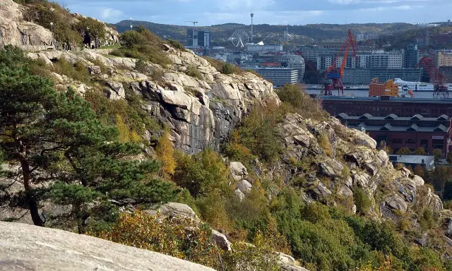 Steniga sluttningar med träd och buskar i Keillers park, med Göteborgs stad och hamnen i bakgrunden.