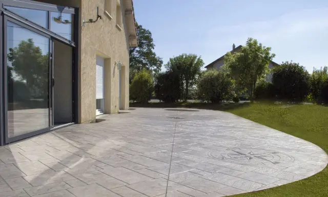 Terraza de hormigón impreso con diseño de brújula, mostrando cómo se hace el hormigón impreso para un acabado elegante y duradero.