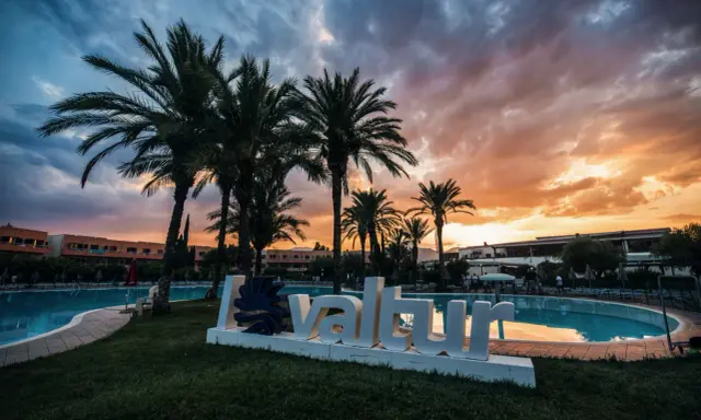 Tramonto infuocato sul Valtur Calabria Otium Resort. Palme e piscina creano un'atmosfera da sogno.