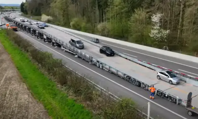 Un puente móvil transporta varios coches por una autopista.