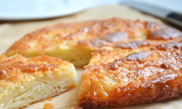 Saftige Kouign Amann mit karamellisierter Kruste, geschichtet und goldbraun gebacken.