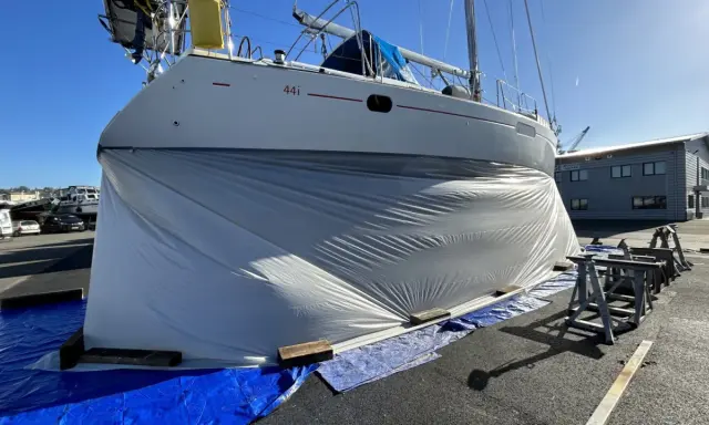 Bateau bâché, prêt pour le sablage de sa coque. Le prix du sablage coque bateau est une étape clé pour sa rénovation.