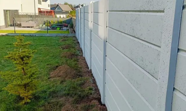 Nowy betonowy płot czeka na aranżację. Jak upiększyć betonowy płot? Sadzimy drzewko i planujemy nasadzenia.
