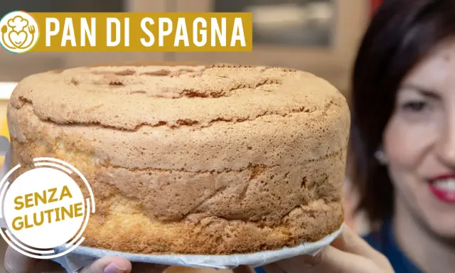 Un soffice pan di spagna senza glutine, pronto per essere farcito. La donna sorride sullo sfondo.