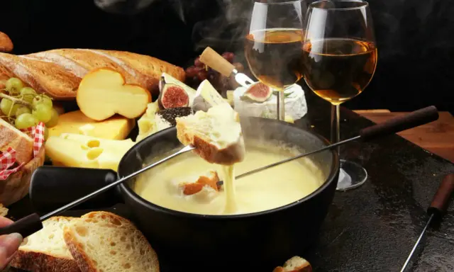 Un délice fumant de fondue au fromage, pain croustillant et vin blanc. Un aperçu des spécialités Auvergne Rhône Alpes.