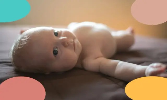Un bebé de 2 meses, con ojos curiosos, yace boca arriba. Parece que este pequeño no duerme, ¡sus ojitos están bien abiertos!