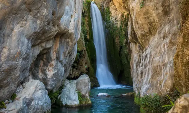 Cascada cayendo en pozas cristalinas, un rincón idílico de piscinas naturales Alicante.