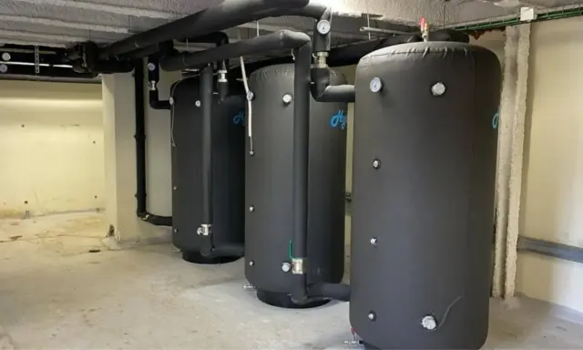 Tres grandes calderas para hoteles, con aislamiento negro y tuberías conectadas, listas para proveer agua caliente.