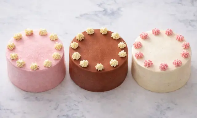 Trois petits gâteaux décorés, parfaits pour une recette de bento cake. Un rose, un chocolat, un vanille.