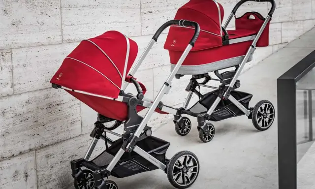 Dwa czerwone wózki dziecięce, eleganckie i stylowe, od renomowanego producenta wózków dziecięcych.