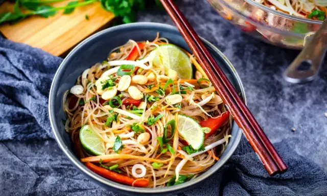 Schüssel mit Glasnudelsalat, Erdnüssen, Limette und knackigem Gemüse. Das Dressing macht ihn unwiderstehlich.
