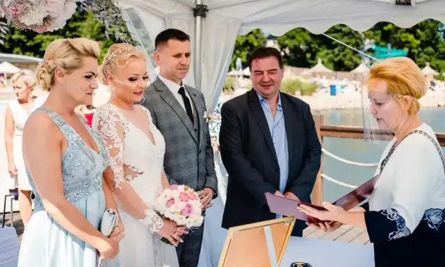 Ślub cywilny po rozwodzie. Para młoda, świadkowie i urzędniczka podczas ceremonii nad wodą.