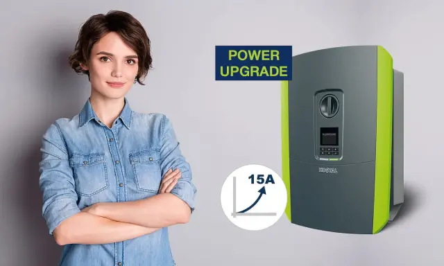 En kvinna med armarna i kors bredvid en KOSTAL Plenticore Plus 10 växelriktare, som symboliserar en "Power Upgrade" med en graf som visar 15A ökning.