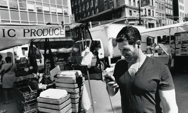 Uomo con auricolari al mercato, un'istantanea di Lee Friedlander.