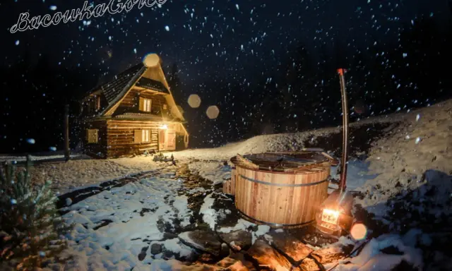 Nocą w bacówce u Winiarskich, przytulny drewniany domek i gorąca balia w śnieżnej scenerii.