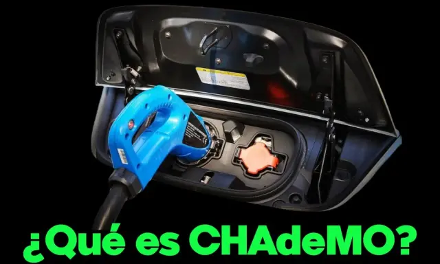 Un conector CHAdeMO azul se inserta en el puerto de carga de un coche eléctrico.