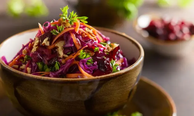 Wykwintna surówka z czerwonej kapusty jak w restauracji, z marchewką, orzechami i żurawiną, udekorowana natką pietruszki.