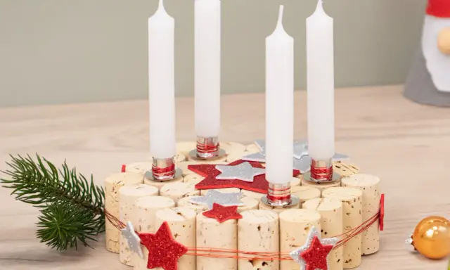 Selbstgemachter Adventskranz aus Korken mit vier Kerzen, Tannenzweig und Glitzersternen. Perfekt zum Adventskranz basteln mit Kindern.