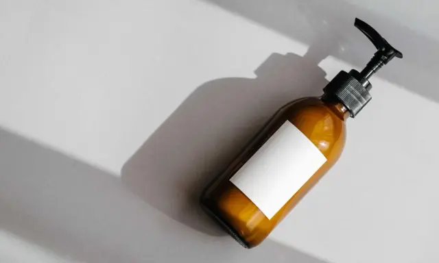 Flacone ambrato con etichetta bianca vuota e dispenser nero. Attenzione agli ingredienti come il cetearyl alcohol fa male.