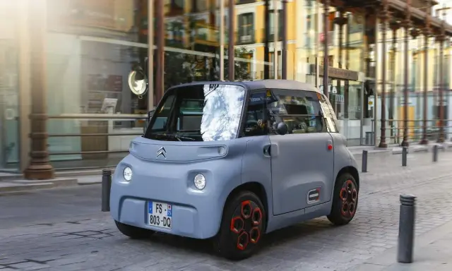 Citroën Ami gris en movimiento por la ciudad. Descubre el carnet AM precio y disfruta de la movilidad urbana.