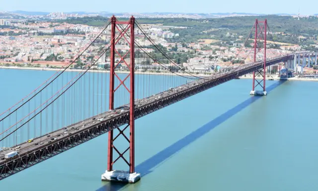 El puente 25 de Abril en Lisboa, con sus icónicas torres rojas, cruza el río Tajo. ¿Cuanto mide el puente de Lisboa? Es un coloso de ingeniería.