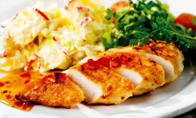 En saftig kycklingfilé serveras med en krämig fransk potatissallad med kyckling och en fräsch grönsallad.