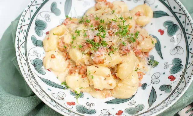 Krämiga gnocchi med salsiccia, toppade med riven ost och färska örter. En härlig rätt som passar perfekt för en mysig middag.