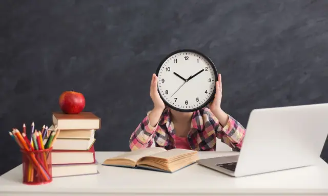 Dziecko z zegarem zamiast twarzy, stos książek, jabłko i laptop. Sierpień godziny pracy, nauka i przygotowania do szkoły.