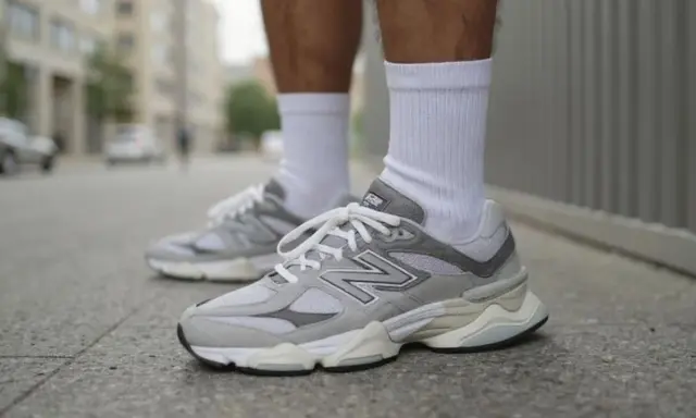 Szare buty New Balance na miejskim chodniku. Stylowy poradnik, jak nosić klasykę.
