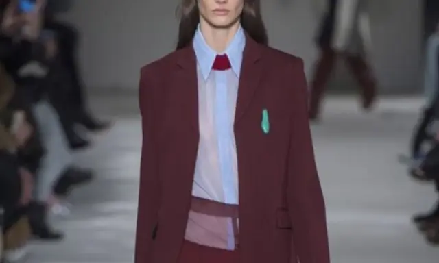 Modella con blazer bordeaux, camicia azzurra e cravatta rossa. Il bordeaux dona un tocco di eleganza sofisticata.