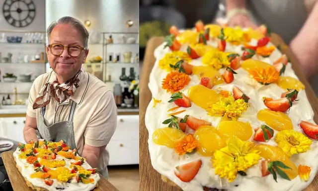 En glad man håller upp en vacker påsktårta i långpanna, dekorerad med grädde, jordgubbar, aprikoser och gula blommor.