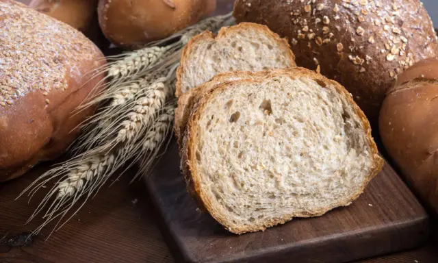 Różnorodne pieczywo, w tym kromki chleba pełnoziarnistego, które sugerują, jakie pieczywo jest dietetyczne.
