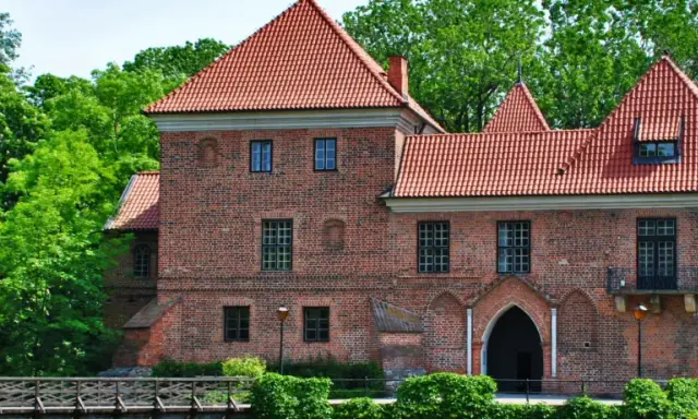 Zamek w Łęczycy, jedna z głównych atrakcji regionu, otoczony zielenią.