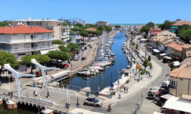Passeggiata sul canale di Cervia, con barche ormeggiate e negozi. Un'ottima idea per scoprire cosa fare a Cervia in una giornata di sole.