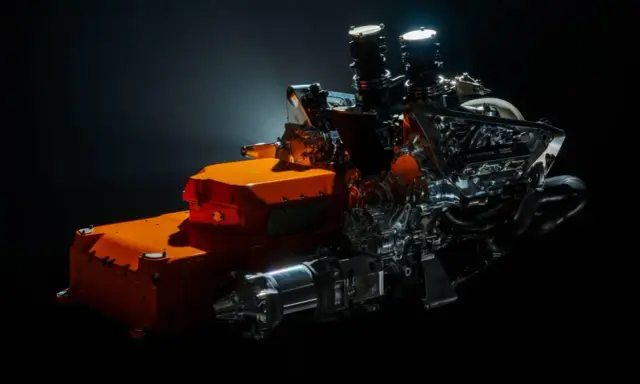Un vistazo a los futuros motores F1 2026: un complejo sistema híbrido con componentes naranjas y metálicos, listo para la velocidad.