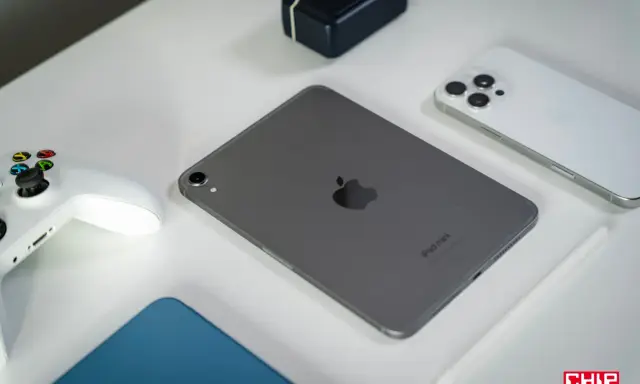 Szary iPad mini, biały kontroler do gier, biały iPhone i rysik na białym tle.