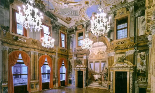 Intérieur somptueux d'un palais labia, avec lustres en cristal, fresques au plafond et tentures de velours rouge.